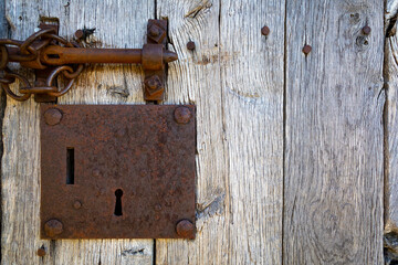 Cerradura y textura de una puerta de madera desgastada por el tiempo