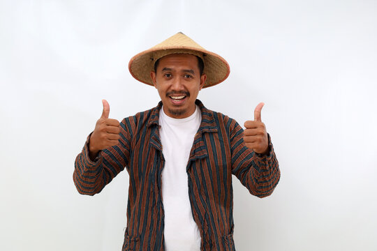 Joyful asian farmer standing while showing thumbs up. Isolated on white background