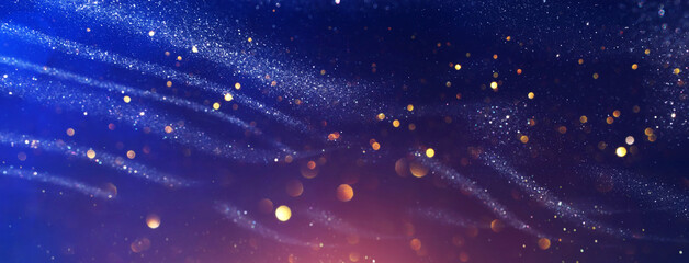 background of abstract glitter lights. gold, blue and black. de focused