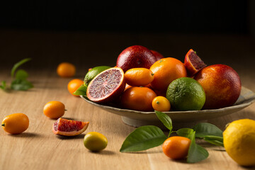 A variety of tropical citrus fruits on a ceramic plate, copy space