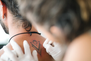 Handpoke minimalist tattoo Detail. close up handpoke Young woman tattoing with Handpoke tattoo...