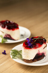creamy dessert with berry jelly and violet flowers on a white plate