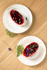 dessert with berry jelly and violet flowers, top view