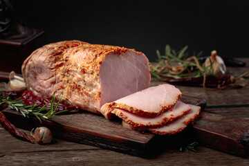 Sliced spicy ham on an old wooden table.