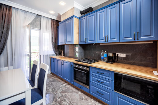 Modern Kitchen In The Art Nouveau Style. Wooden Countertop And Blue Facade Of Kitchen Furniture. Appliances.