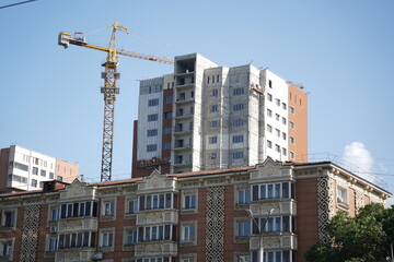 Fototapeta na wymiar Almaty, Kazakhstan - 04.26.2022 : A residential building with an old design and a new residential complex under construction