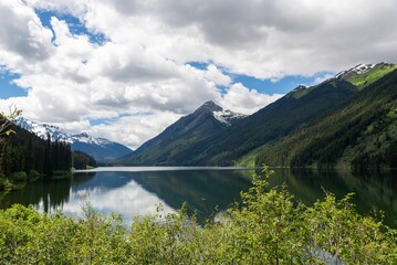 View of Duffey Lake in Provincial Park with forest on mountains against blue cloudy sky, Canada, BC