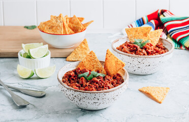 Chili con carne in a clay bowl on a concrete or stone rustic background- traditional dish of mexican cuisine.Top view.