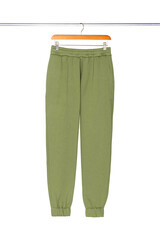 Sweatpants from a green sweatshirt hang on a wooden hanger, front view. The concept of modern comfortable sportswear and detox.