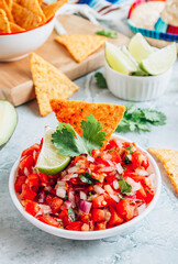 Salsa sauce and nacho chips on gray marble background. Mexican salsa sauce