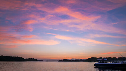 Obraz premium Sunset over a lake in Ireland with a boat moored to the side