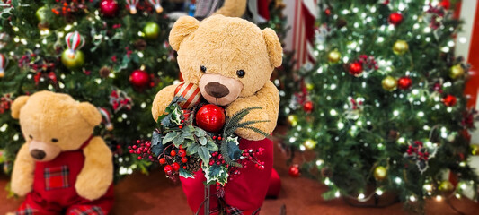christmas tree decorated with balls and lights and christmas presents, teddy bear in christmas color, with little red bow