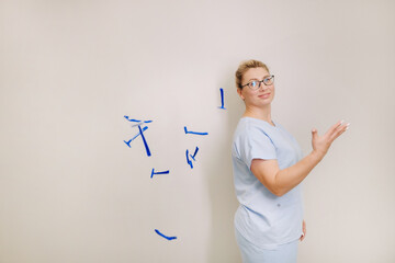 a female laser hair removal master in a blue robe throws shaving machines on a light background