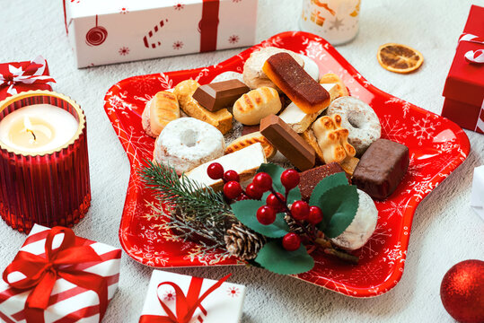 Top view of Nougat christmas sweet,mantecados and polvorones with christmas ornaments on a christmas star shaped red plate. Assortment of christmas sweets typical in Spain