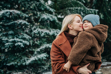 mother with son near spruce in snowy garden in winter time, P