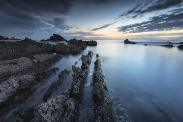 Lunga esposizione all'ora blu sulla scogliera di Antignano, Punta del Casotto, provincia di Livorno, Toscana, Italia, Europa