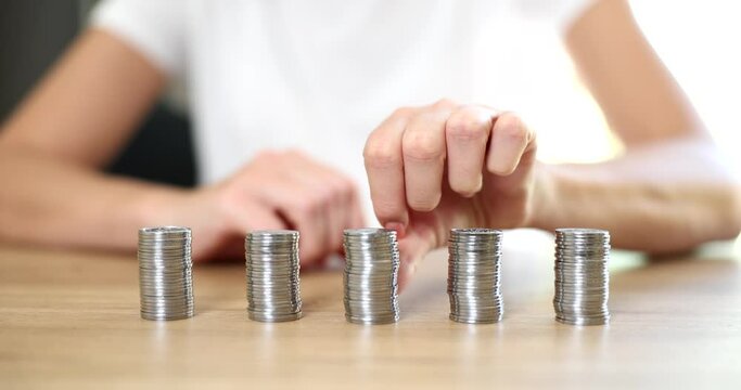 Equal stack of coins on the wooden table, close-up