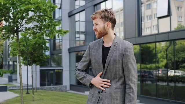 Gastritis. Business man manager guy having liver abdominal pain standing outdoor near office building, businessman having pain in stomach outside, male sick. Stomach ache due to poor unhealthy diet. 