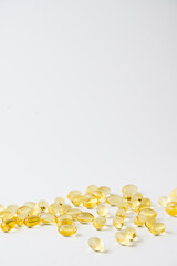 View of evening primrose oil pills on white background, vertical, with copy space