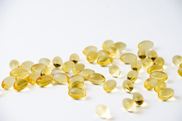 closeup of evening primrose oil pills on white background, horizontal, with copy space
