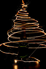 Golden bottle of champagne with sparklers on a dark background