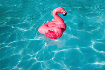 Summer beach concept. Pink Inflatable flamingo toy floating in a pool © Mariya