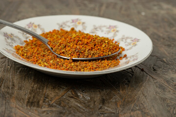 close up of a plate full of pollen on a wooden table