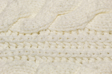 Close-up on a hand-stitched beige warm cozy fabric with a defocused part in the foreground