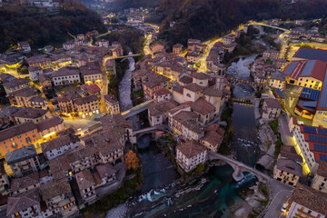 Fototapeta premium Aerial villagescape - old church and crossing rivers with mountains backdrop