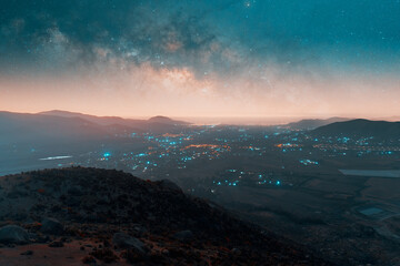aerial panoramic view of the milky way over the city in the valley at night