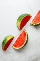 Top view of sliced green watermelon on light surface