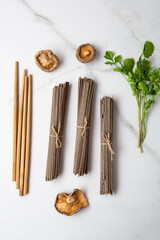 Fototapeta na wymiar Ingredients for cooking soba noodles food mushrooms chop stick on light surface