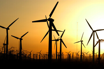 Fototapeta premium Silhouetted Windmills in the Palm Springs, California at smoky sunset during a major wild fire.