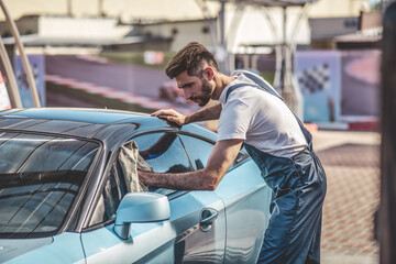 Experienced auto detailer cleaning a customer vehicle outside