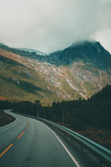 Naklejka premium Empty road leading towards mountains on a moody autumn day in Norway