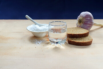 Bread, garlic, salt, vodka on the table.