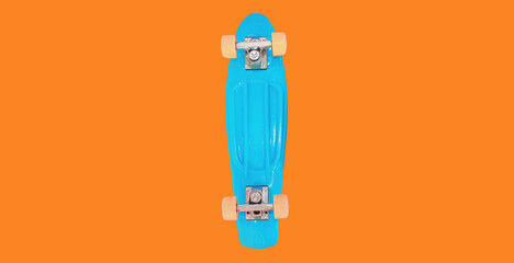 Close up of stylish blue skateboard on colorful orange background © rohappy