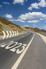 Año nuevo 2023 o concepto de inicio. Palabra 2023 escrita en la carretera con curvas y en ascenso....