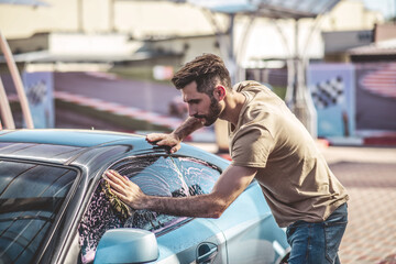 Fototapeta na wymiar Automotive detailer cleaning the customer motor vehicle