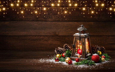 Merry Christmas! Lantern with candles and Christmas decorations on a wooden background