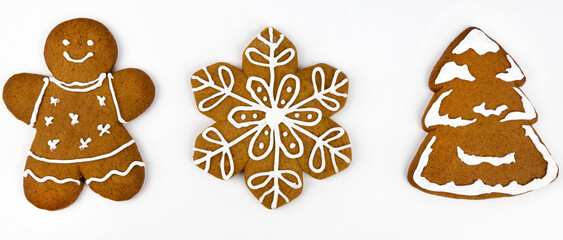 Christmas gingerbread cookies with glaze in the shape of a man, a Christmas tree and snowflakes, on a white background.