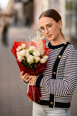 view on pretty woman with bouquet of white roses in her hand