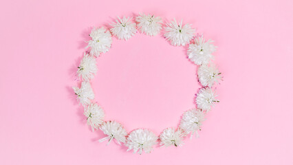 Heads of white chrysanthemum flowers form a circle. Floral frame with copy space in the center. Holiday greeting card.