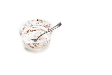 An eaten and empty glass of tiramisu on a white background. Italian food concept.