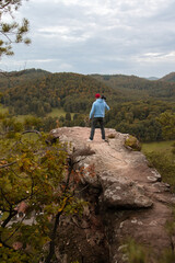 Ein Mann genießt nach der Wanderung, vom Gipfel des Berges, die atemberaubende Aussicht der Landschaft