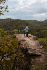 Fototapeta premium Ein Mann fotografiert die atemberaubende Landschaft im Pfälzer Wald