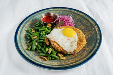 cutlet with fried egg and green beans