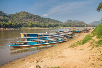 Traditional lao sampan wooden boats at Mekong river bank. Luang Prabang, Laos