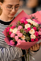 Close-up view on fresh flowers of bouquet in hands of woman