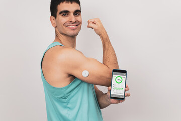 A young man shows his mobile with a continuous glucose monitor blood sugar test application, glucose measurement. - obrazy, fototapety, plakaty